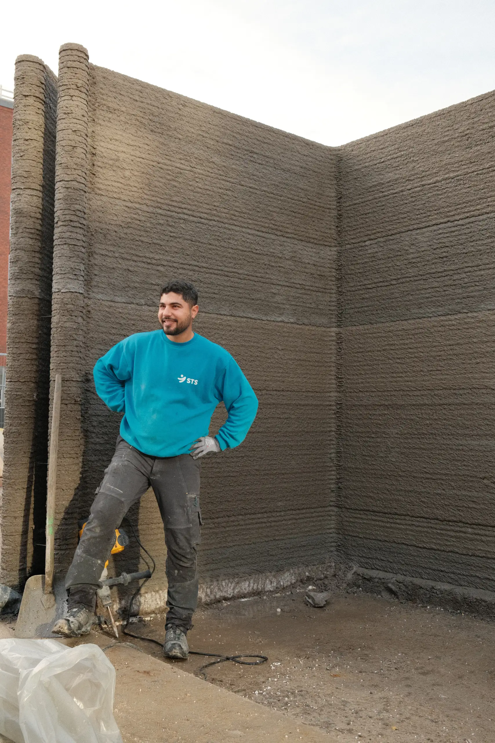 Image of 3D-printed concrete layers, with man in foreground